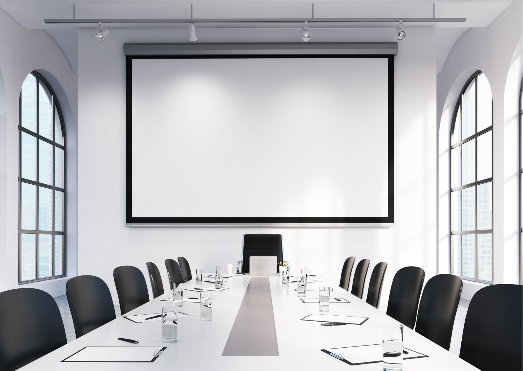A stark white and empty boardroom with black chairs all faced towards a blank projector board