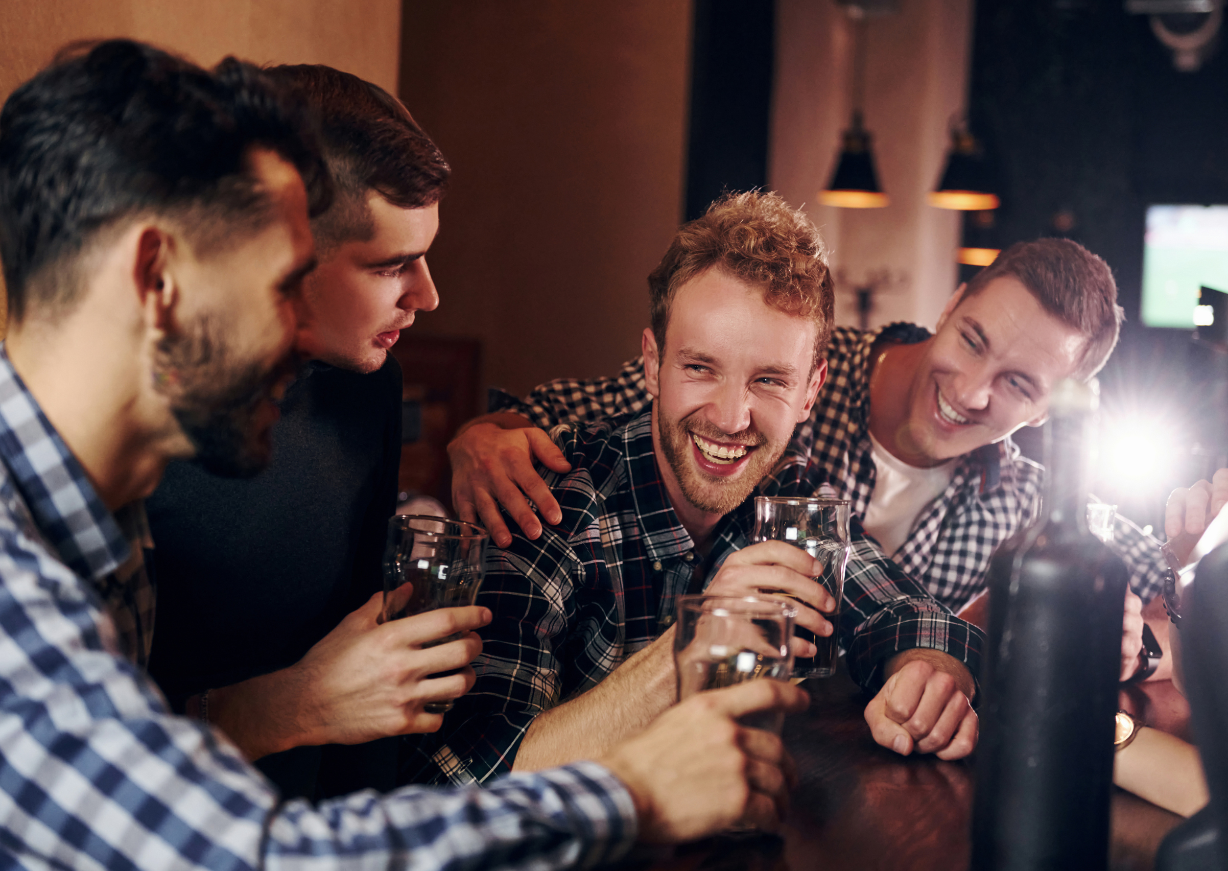 A bunch of lads laughnig around a few beers