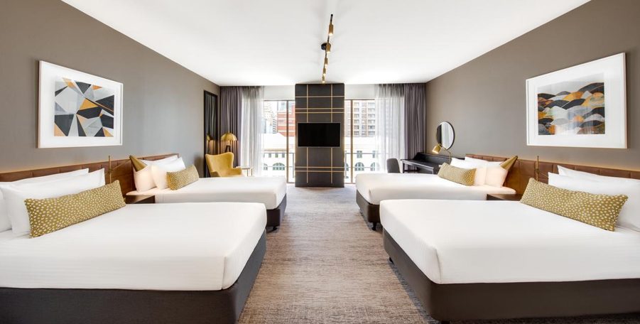 Hotel room with four double beds and a TV at the far end