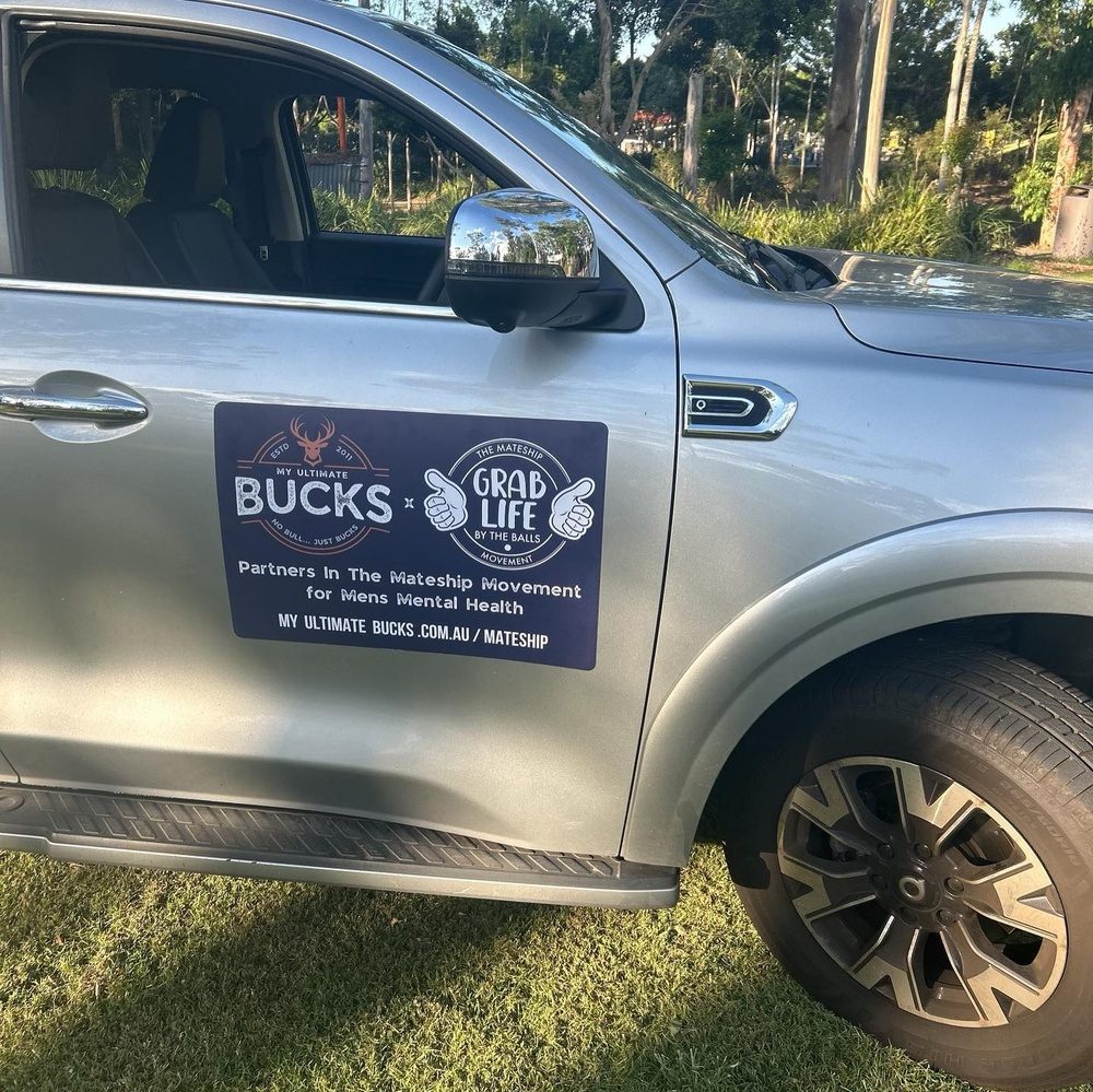 A car door sign reading Partners in the mateship movement for men’s mental health
