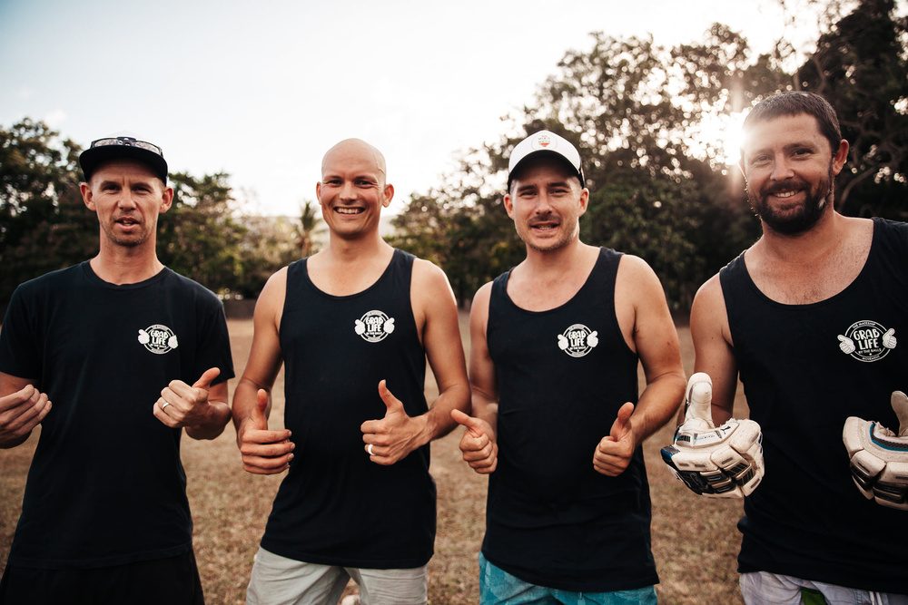 Four blokes in Grab Life By The Balls singlets giving a thumbs up