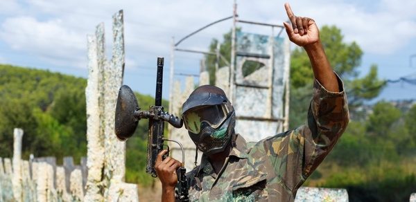 A paintballer with his arm raised in celebration