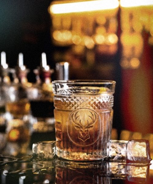 A whisky glass on a bar under warm light