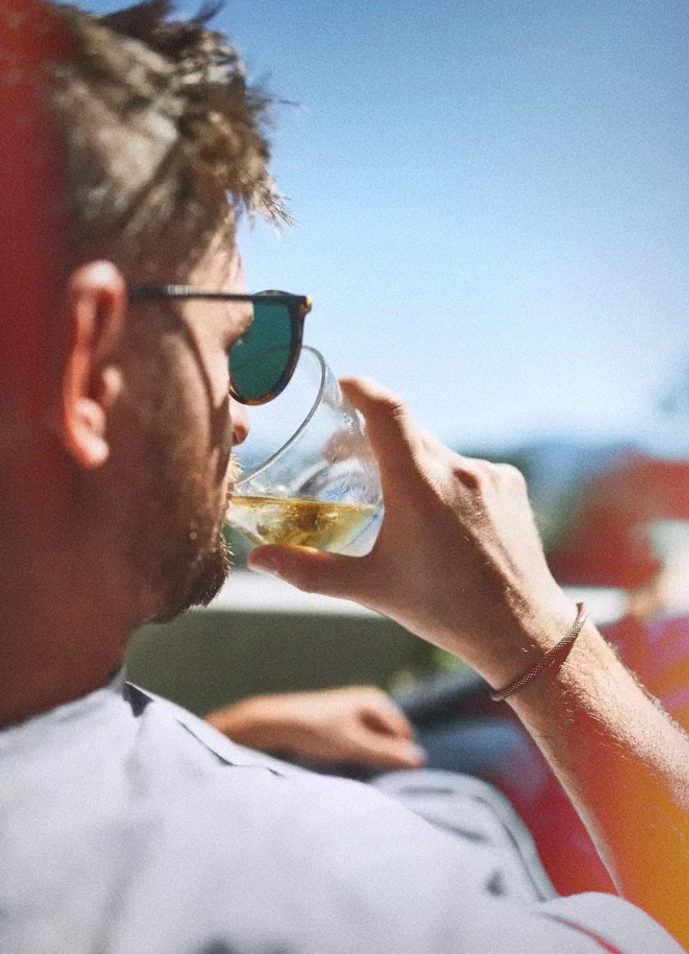 A bloke in sunglasses with a cold drink in the sun