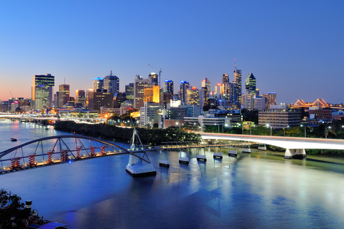 The Brisbane CBD skyline at dusk from across the river, bridges lit up