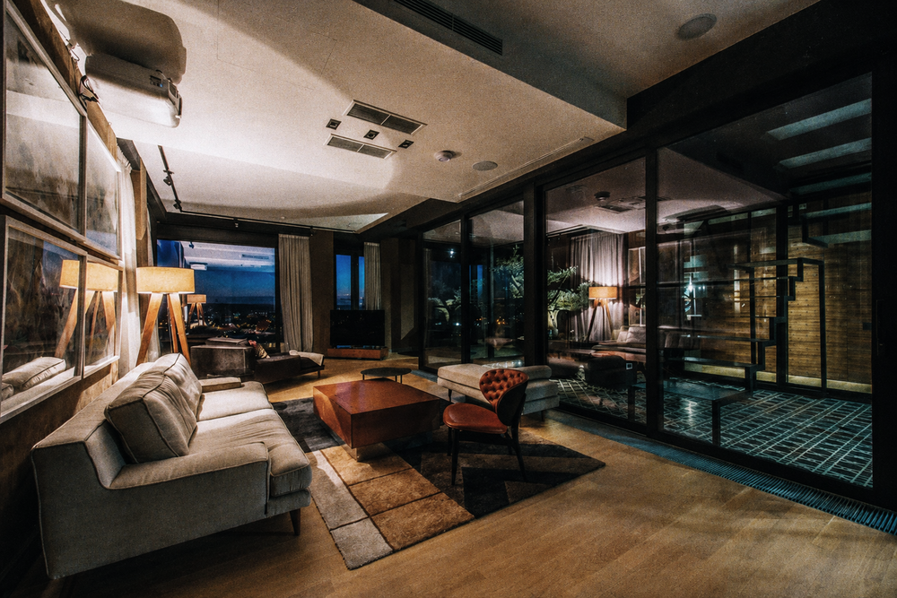 An apartment lounge with sofas and floor-to-ceiling windows