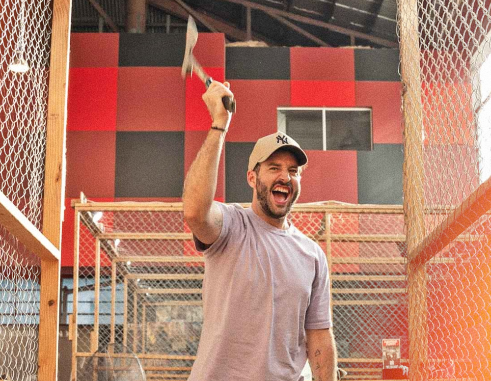 A buck laughing while axe throwing at a Melbourne bucks party