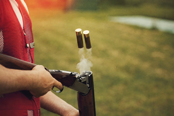 Spent shells flying out of a shotgun on a clay range
