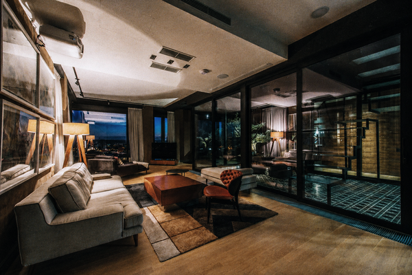 A modern apartment lounge at night with floor-to-ceiling windows