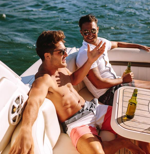 Blokes relaxing on the deck of a boat, drinks in hand