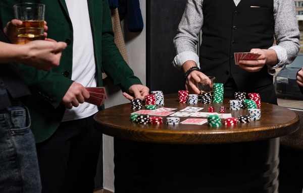 Players around a poker table stacked with chips