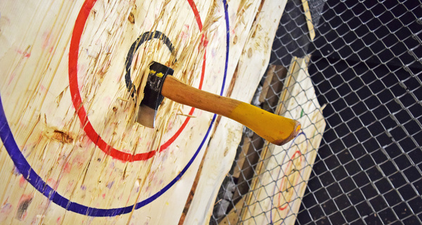An axe sunk into a red and blue throwing target