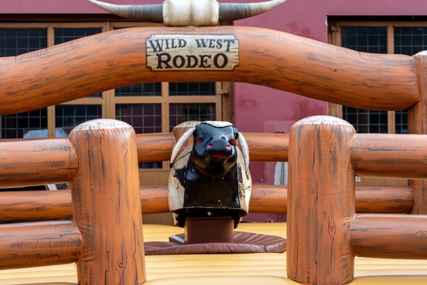 A mechanical bull in a Wild West rodeo pen
