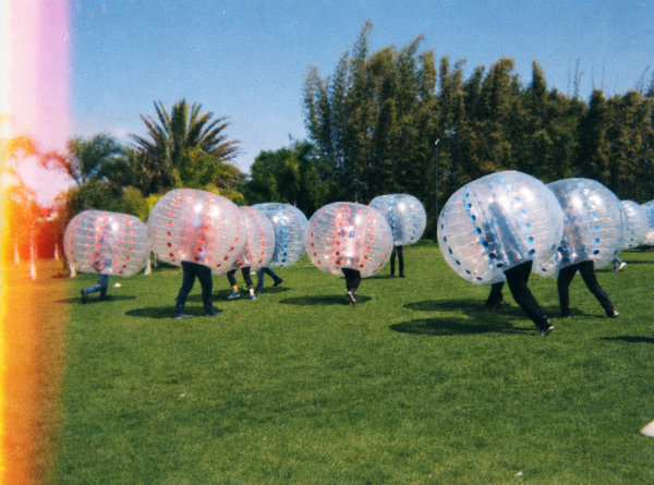 Blokes in bubble suits squaring up on a grass field