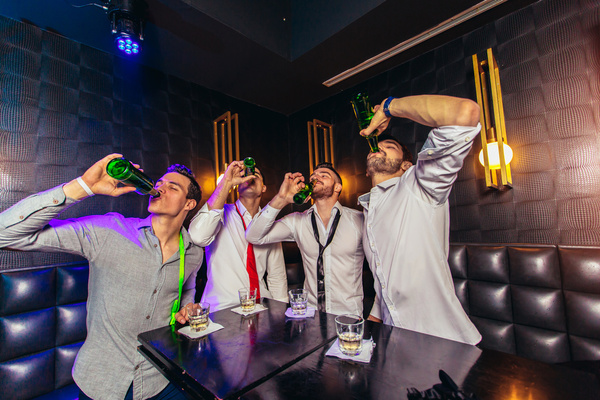 A bucks crew in white shirts partying in a club booth