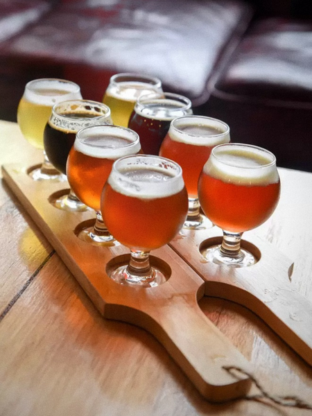 A tasting paddle of craft beers on a timber bench