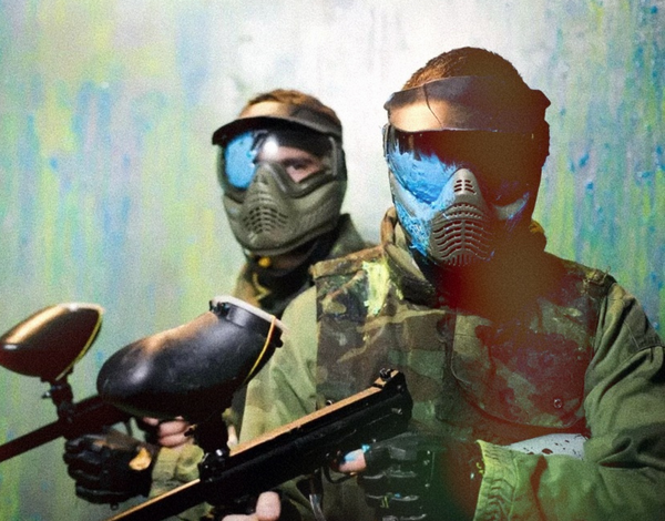 Two paintballers in masks holding their markers