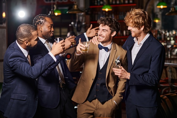 A bucks crew in suits laughing with drinks