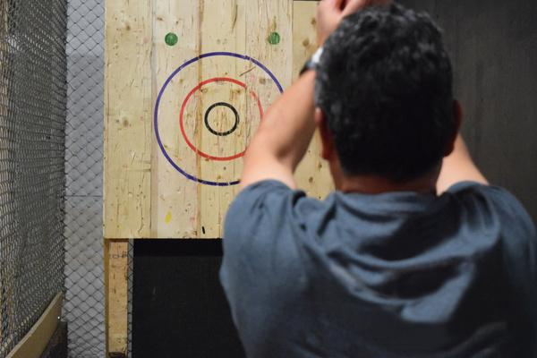 A bloke lining up a throw at an axe target