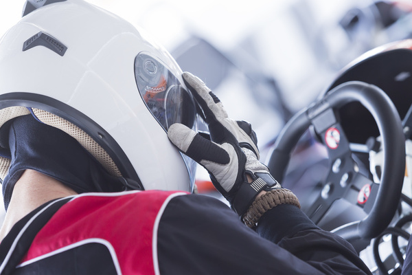 A helmeted driver gripping the steering wheel