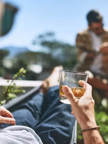 A bloke relaxing in the sun with a drink in hand