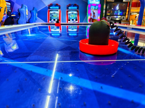 A neon-lit air hockey table in an arcade