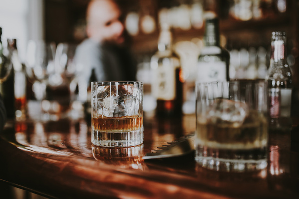 Two glasses of whisky on a bar top