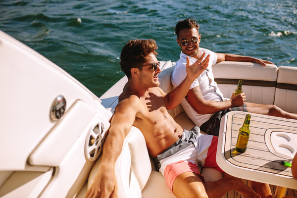 Mates with drinks relaxing on a speedboat