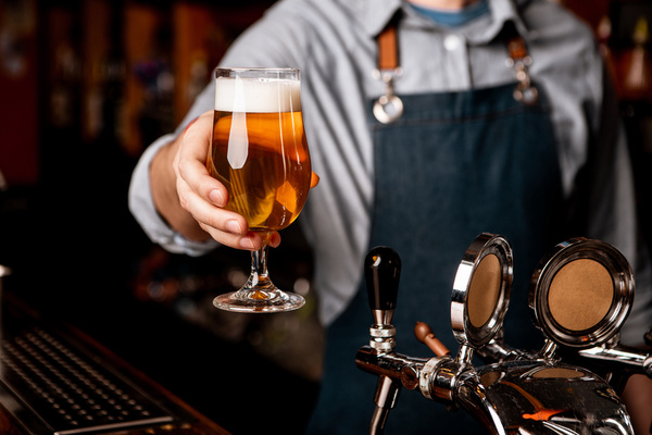 A barman handing over a fresh pint