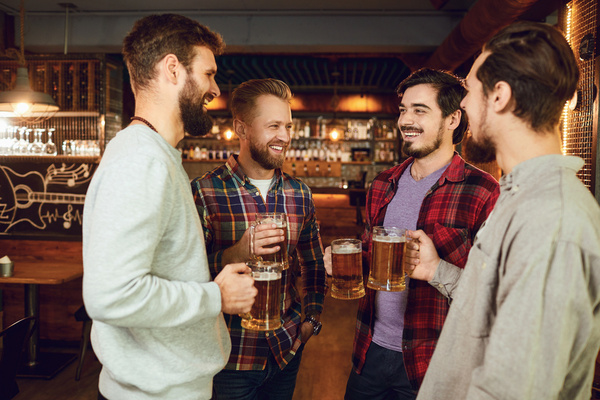Four mates with pints at the pub