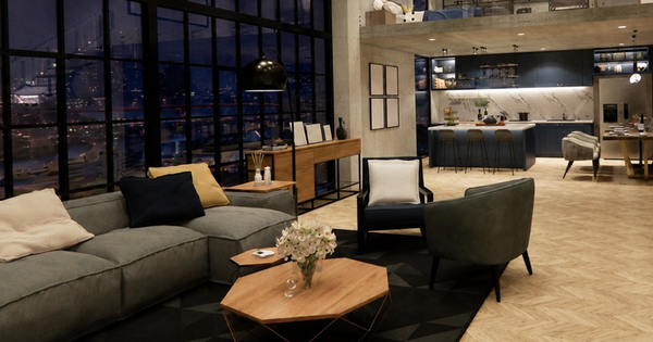 A modern apartment lounge with a grey sofa and the kitchen behind