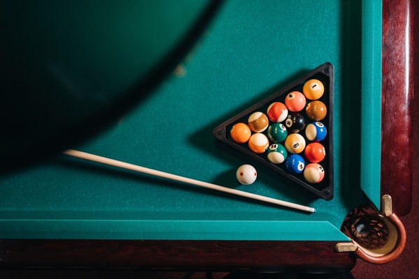 A pool table with the balls racked