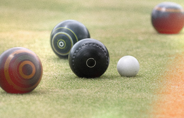 Lawn bowls lined up near the white jack