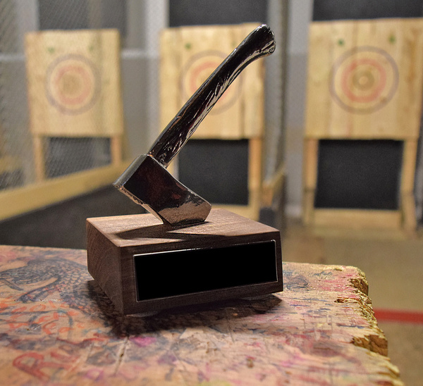 An axe standing in a block in front of the throwing targets