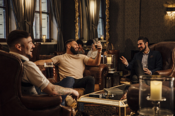Blokes relaxing in leather armchairs in a dim lounge bar