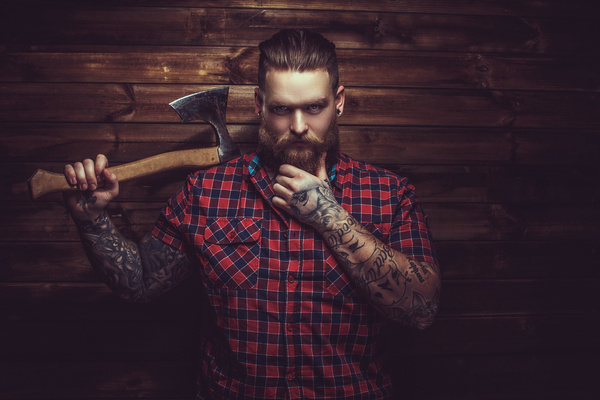 A tattooed bloke holding an axe