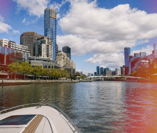 The bow of a boat on the Yarra with Southbank's towers ahead