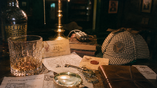Detective props, a magnifying glass and a glass of whisky on a desk