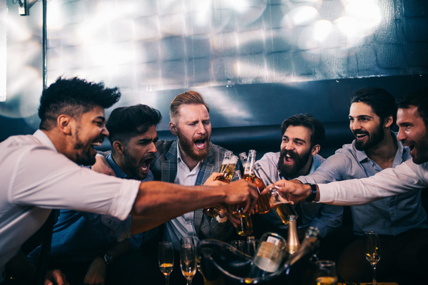 A crew clinking bottles around a table