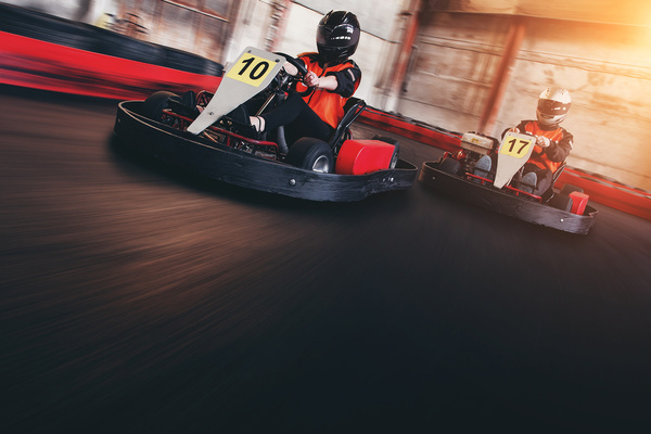 Two go-karts racing round an indoor track