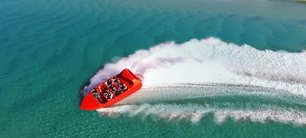 A jet boat carving a spray across the water
