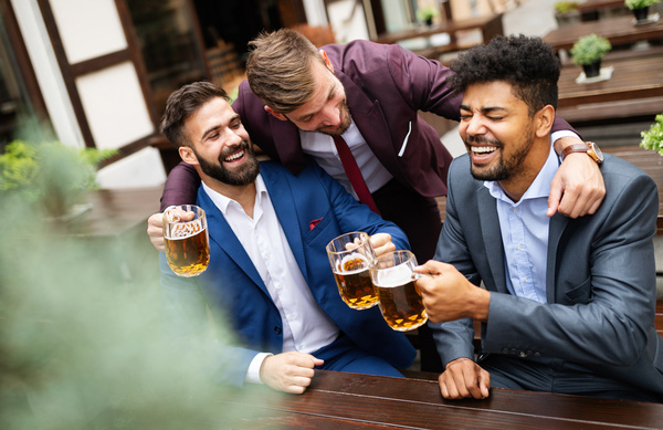 Blokes in suits laughing over beers