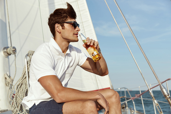 A bloke sipping a drink on a yacht deck